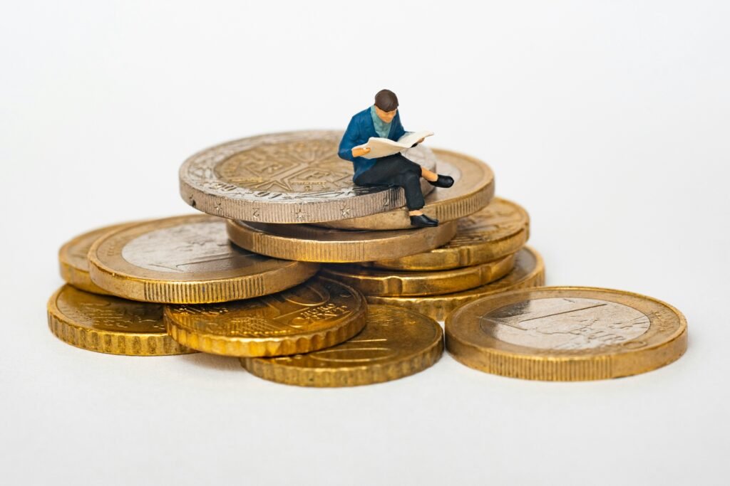 Man sitting on pounds reading a newspaper